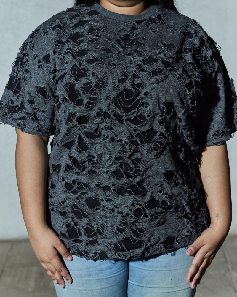 Female model wearing grey Torn oversized T-shirt front view – Volfsbane women’s grunge streetwear
